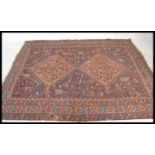 A 20th Century Turkish woven rug having a red ground with intricate geometric patterning including