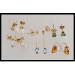 A group of 9ct gold earrings to include green stone studs, crystal drops, light blue stone drops,