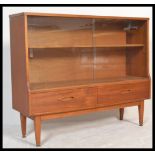 A retro 1970's teak wood glazed display cabinet having a pair of smoked glass sliding doors above