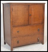 A mid 20th Century oak tallboy, panel doors opening to reveal shelved interior over two long drawers