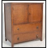 A mid 20th Century oak tallboy, panel doors opening to reveal shelved interior over two long drawers