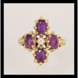 A hallmarked 18ct gold ring set with four oval cut amethysts in a quatrefoil setting having a