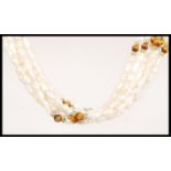 A vintage 20th century baroque pearl multi strand necklace having tigers eye and gold spacers and