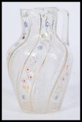 A 19th century Victorian Bohemian style glass jug having hand painted floral decoration with gilt