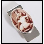 A sterling silver novelty money clip having an enamel panel depicting an erotic scene. Stamped 925