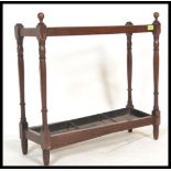 A Victorian 19th century mahogany stick stand in the manner of Shoolbred, London. Raised on turned