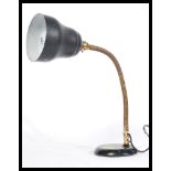 A vintage retro 20th Century industrial anglepoise desk lamp raised on a circular base with brass