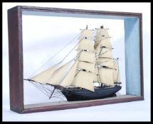 An early 20th Century scratch built model of a sailing ship at full mast, set within an ebonised