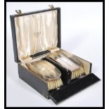 A pair of early 29th Century silver hallmarked brushes in a fitted J. Benson Ltd case. Hallmarked