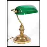 A vintage retro 20th century gilt brass bankers lamp raised on a circular base with adjustable green