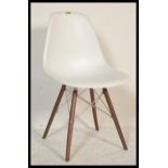A contemporary dining slide chair in the style of Eames DSW chair, having a white bucket seat raised