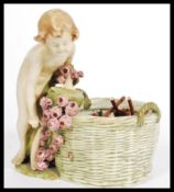 An Austrian bisque ware  potpourri basket in the form of a cherub / child with floral basket leaning