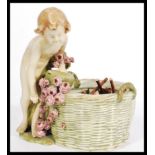 An Austrian bisque ware  potpourri basket in the form of a cherub / child with floral basket leaning