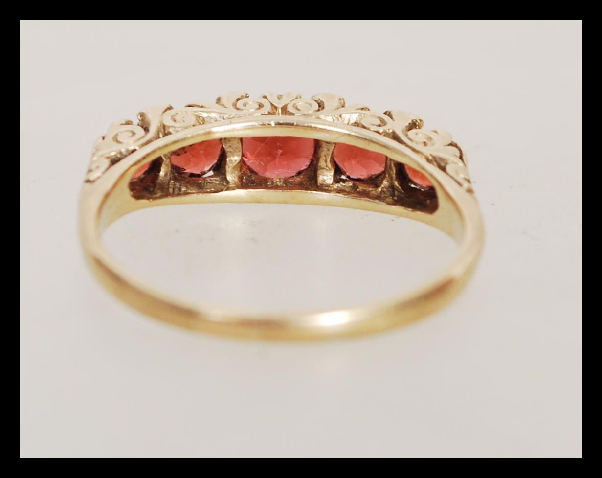 A hallmarked 9ct gold five stone ring having graduating faceted red stones in scrolled mount. Weighs - Image 3 of 4
