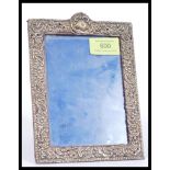 A hallmarked early 20th century silver hallmarked easel back picture frame having Rococo influence
