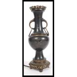 An early 20th century Japanese bronze table lamp raised on bronze socle base with twin handles