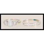 Two stamped 9ct white gold rings to include a ring channel set with round white stones (size R.5),