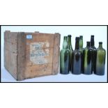 A vintage 19th century wooden shipping crate along with a group of 19th century wine bottles.