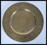A 19th Century Chinese brass charger plate of circular form having decoration of dragons and