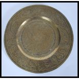 A 19th Century Chinese brass charger plate of circular form having decoration of dragons and