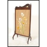 A Victorian 19th century mahogany Art Nouveau firescreen with tapestry centre being glazed and