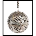 A Chinese / Tibetan silver white metal incense ball having scrolled decoration with birds of
