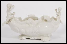 A 20th century Blanc De Chine Parian ware Italian centerpiece of scrolled form having cherub
