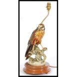 A 20th Century ceramic table lamp in the form of a bird of prey, the bird sat on a naturalistic base