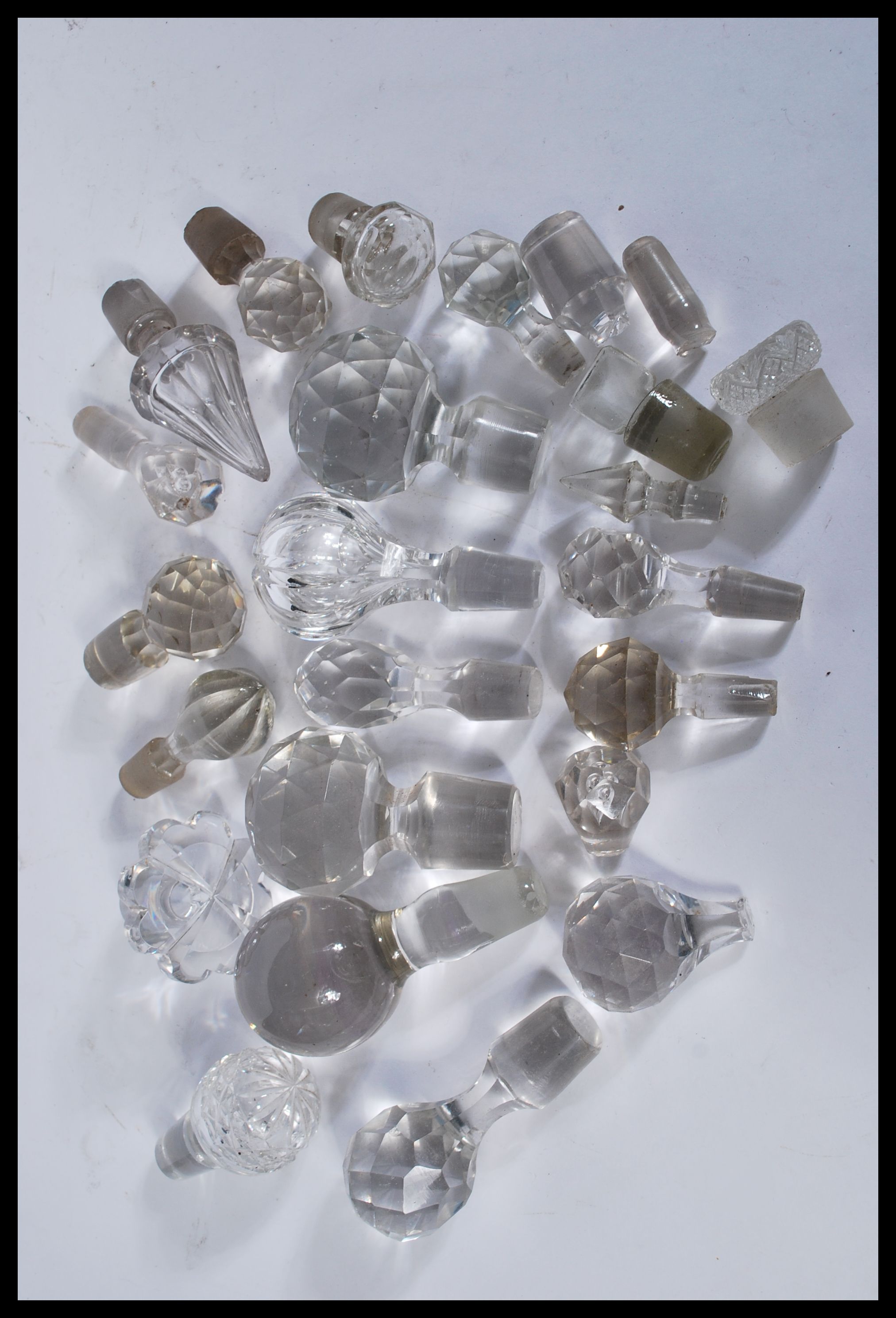 A collection of glass decanter / bottle stoppers of various forms most being crystal cut glass