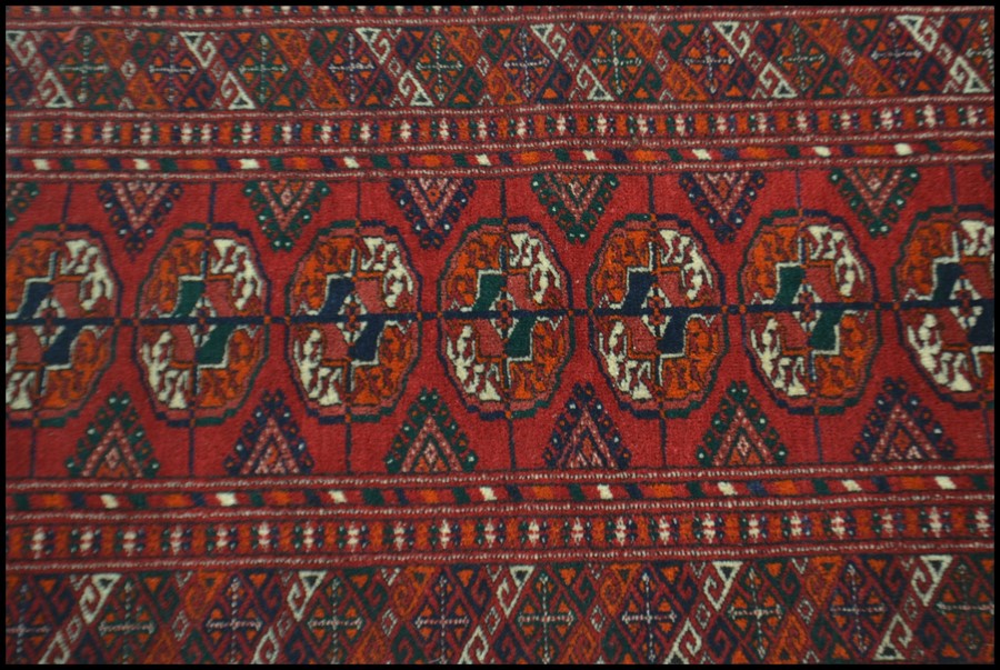 An early 20th century Islamic - Persian Bokhara rug with burnt orange ground having geometric - Image 2 of 4