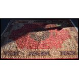 A Persian Islamic Keshan carpet having a red groun