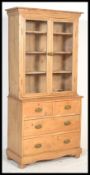 A Victorian 19th century country pine bookcase on chest of drawers. Raised on bun feet with short
