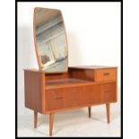 A 1970's retro Danish influence teak wood dressing table chests being raised on turned legs with two