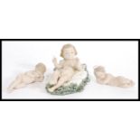 A group of three LLadro and Nao figurines to include Lladro reclined cherub with hands raised,