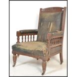 An 19th Century Victorian mahogany faux leather library armchair. The chair raised on turned legs