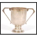 A hallmarked early 20th century silver twin handled goblet / trophy cup raised on stepped circular