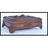 An early 20th century Edwardian carved oak writing box having carved feet, key escutcheon and lid.