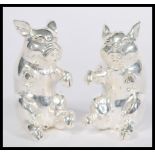 A pair of silver condiments in the form of pigs sitting on their hind legs. Weight 104.7g. 5cm high.