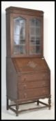 A 1920's Edwardian oak bureau bookcase with twin leaded glass doors over a fully appointed fall