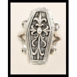 A sterling silver ring in the form of a coffin having a hinged door revealing a spooky