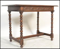 An 18th century Jacobean revival carved oak lowboy writing table desk being raised on block and