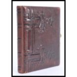 A vintage 20th Century photograph album having a leatherette cover with illustrated decorative pages