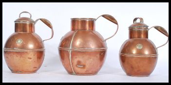 A set of 3 early 20th century Guernsey copper lidded milk jugs of graduating form with shaped