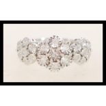 A hallmarked 9ct white gold triple cluster ring having three flowerheads of illusion set white