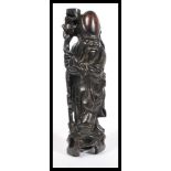 An early 20th century Chinese carved hardwood figurine of an elder having silver inlay. The figure