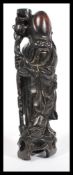 An early 20th century Chinese carved hardwood figurine of an elder having silver inlay. The figure