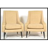 A pair of mid 20th century vintage / retro armchairs - wedge chairs being raised on turned