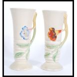 A pair of early 20th century Clarice Cliff vases of tapering cylindrical form having vine and leaf