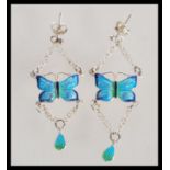 A pair of silver Art Deco style drop earrings having enamelled blue and green butterflies.