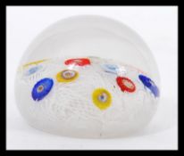 A 20th Century glass paperweight with random murrine canes atop a muslin ground cased in a clear